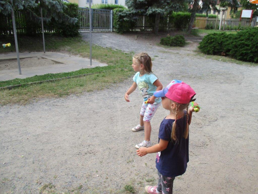 Zwei Kinder werfen mit Wasserblumen